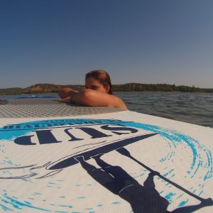 Chica apoyada en la tabla de Paddle Surf